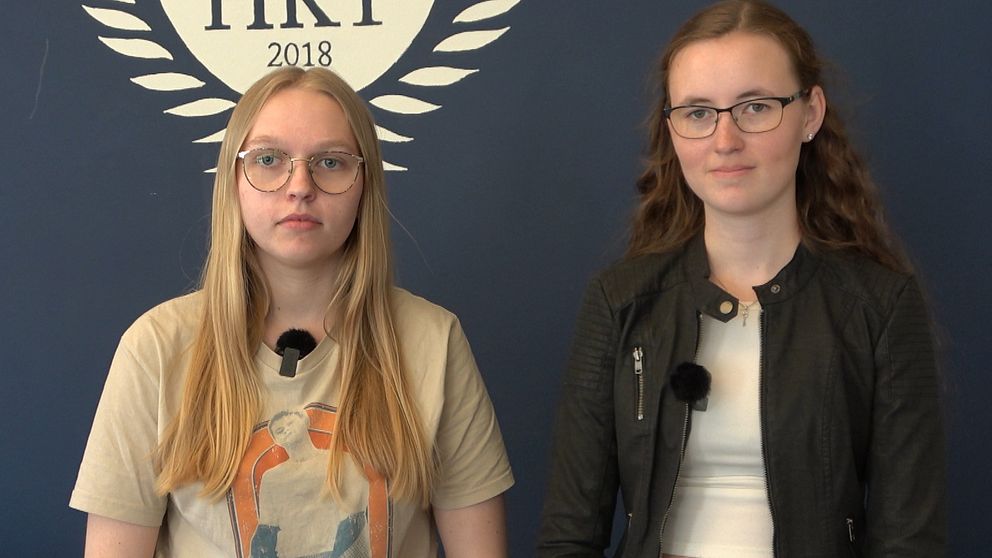 På bilden kan man se eleverna Elin Sundkvist och Lovisa Hallén. De står inomhus och tittar in i kameran. Båda har glasögon på sig.