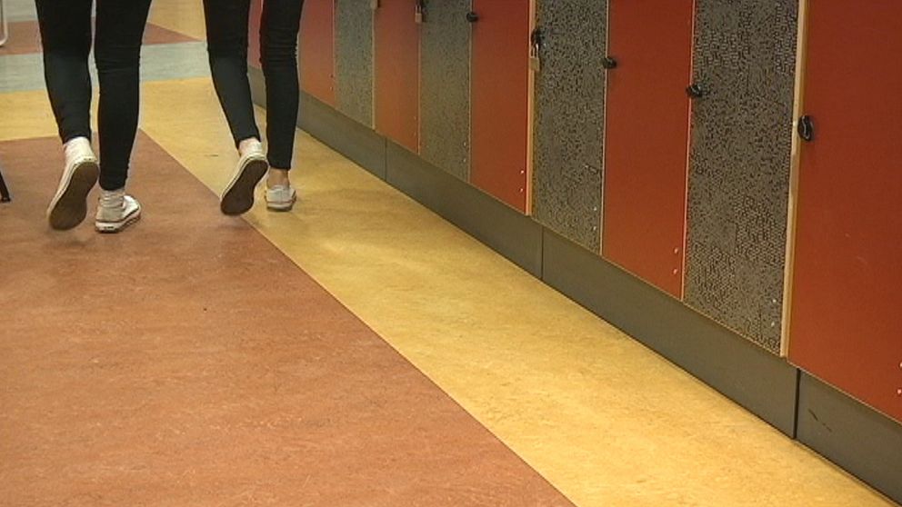 ben och fötter på två elever framför ett skåp i en skolkorridor