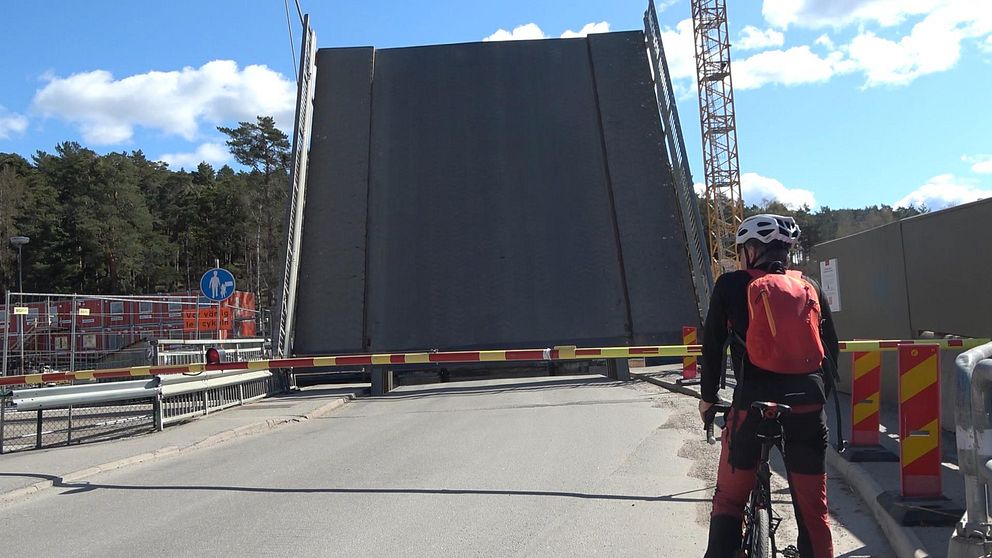 Cyklist framför en broöppning.