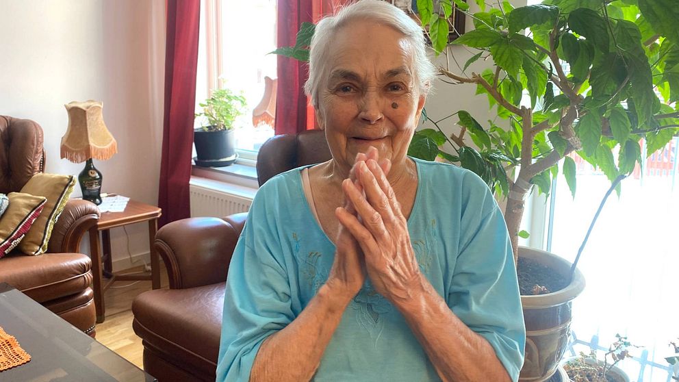 Bild på 91-åriga Leila som ler och håller händerna upp i en applåd.