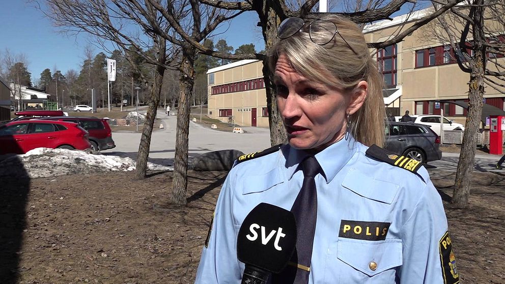 Blond kvinna i poliskläder står utomhus och blir intervjuad.
