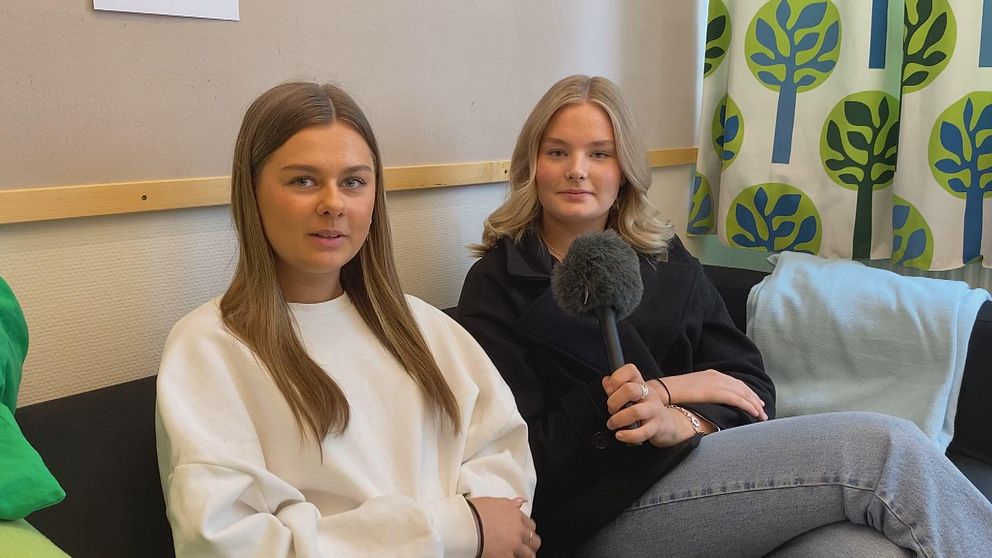 Eleverna Alva Nordenstål (till vänster) och Matilda Olsson (till höger) går i årskurs ett på ekonomiprogrammet på Slottegymnasiet i Ljusdal. Här sitter de i en soffa i ett grupprum i skolan och berättar om sitt projekt där de driver ett eget företag på skoltid.