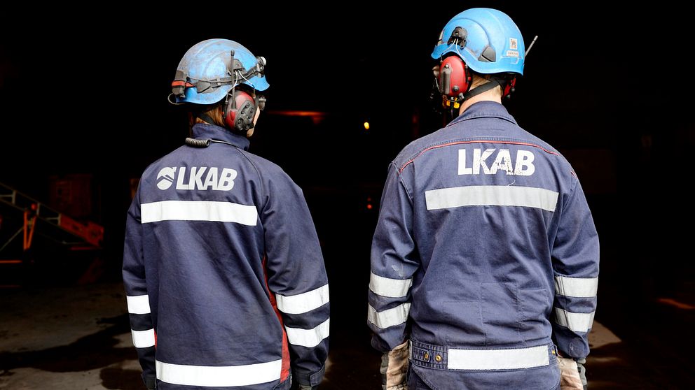 Bild på två gruvarbetare som ska gå in i en gruvgång.
