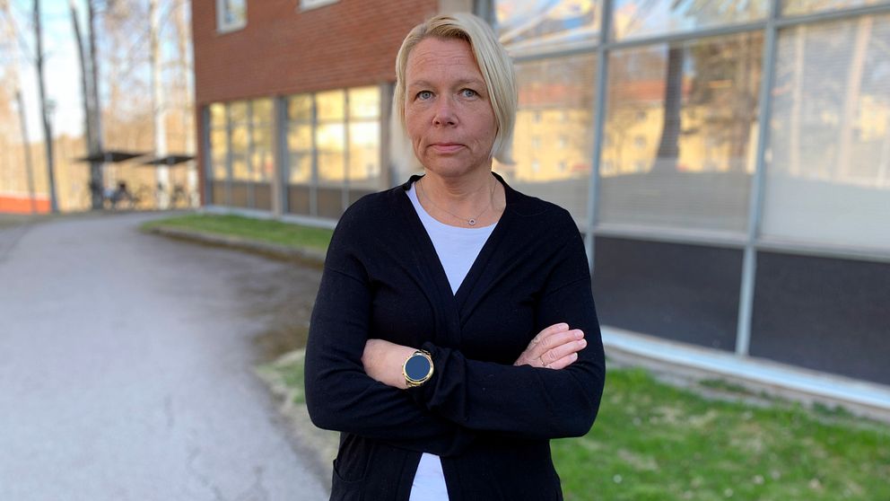 Fältsocionomen Malin Åström, en kvinna i medelåldern med blont hår, står utomhus med armarna i kors.