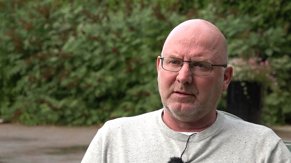 Centerpartistiska kommunalrådet Mikael Westin tittar in sitter utomhus med grå tröja och glasögon.