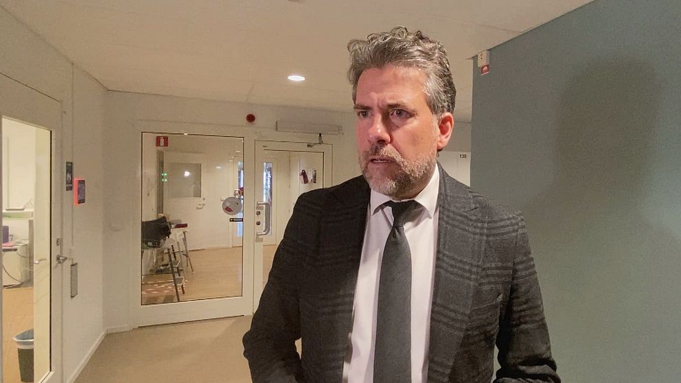 Migrationsverkets generaldirektör, Mikael Ribbenvik, står i en korridor.