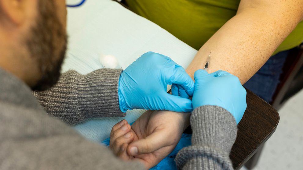 En man vaccinerar en person mot apkoppor på en vaccinationsmottagning i Texas.