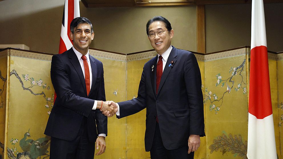 Storbritanniens premiärminister skakar Japans premiärminister Fumio Kishidas hand.