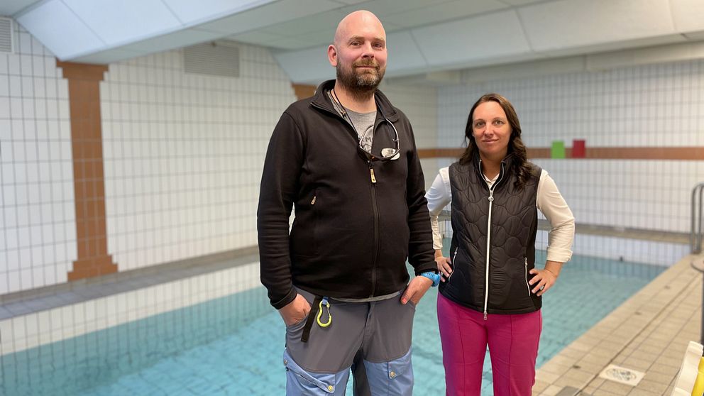 Kommunalrådet Angelica Karlsson (C) och idrottsläraren Patrik Roth berättar om eleverna på Kvarndammskolan som simtränar i en liten bassäng.