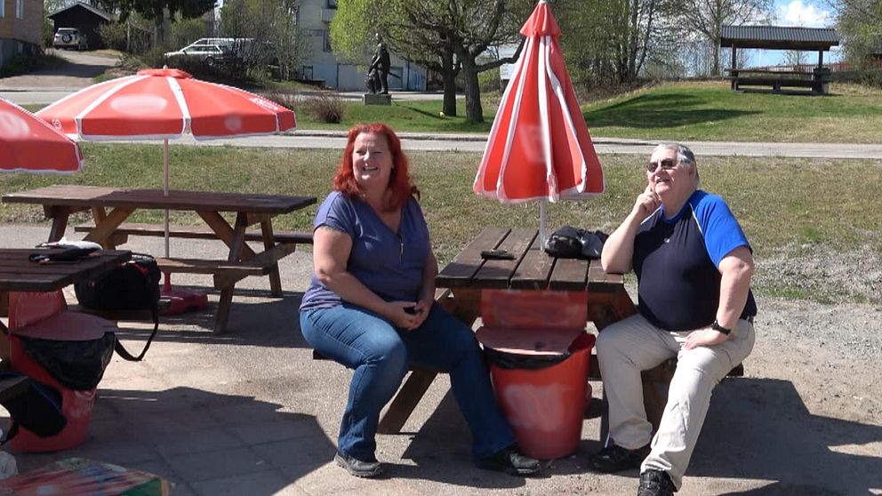 Butiksägaren Mikaela Karlsson, till vänster, och skoterklubbens ordförande Gunnar Hedin, till höger, sitter på bänkarna utanför livsmedelsbutiken i Lillhärdal. De berättar om den nya SOT-punkten som är placerad bakom butiken och vad den kommer att betyda för byn.