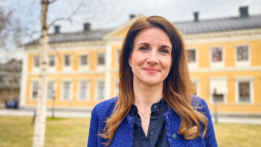 Effie Kourlos centerpartiet står framför gul träbyggnad i Östersund