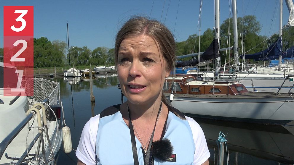 Jenny Blomberg, sjösäkerhetsexpert på Transportstyrelsen, står framför båtar i en hamn. Hon berättar om säkerhet till sjöss.