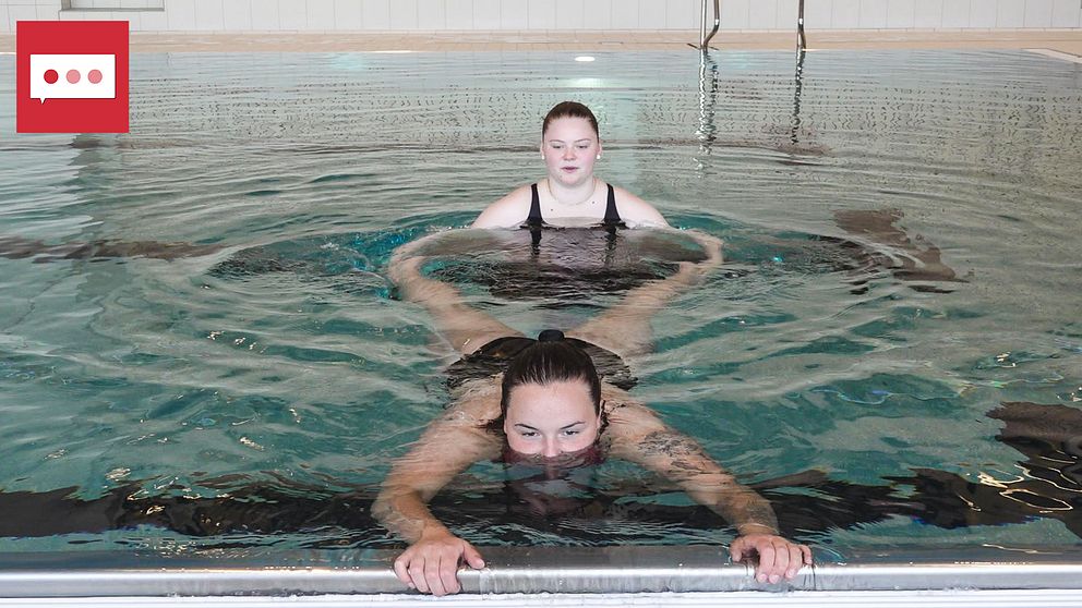 En bild på två tjejer, Victoria Lundqvist och Alice Tengelin, i en pool. Den ena av dem flyter på mage i vattnet och håller i poolkanten och den andra håller i hennes ben.