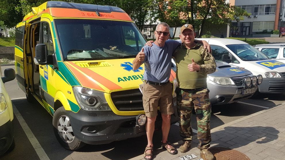 Hasse Hansson och en ukrainsk soldat framför ambulansen från Region Skåne.