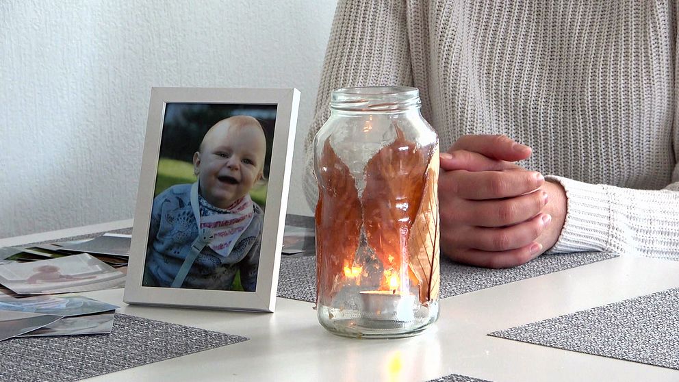 Matteos mamma sitter vid köksbordet vid en ljuslykta och en bild på sin son.