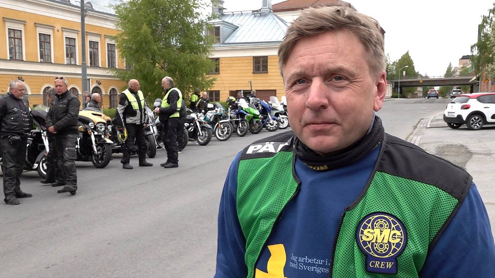 En man i grön väst står framför 20 parkerade motorcyklar vi Jämtlands länsresidens.