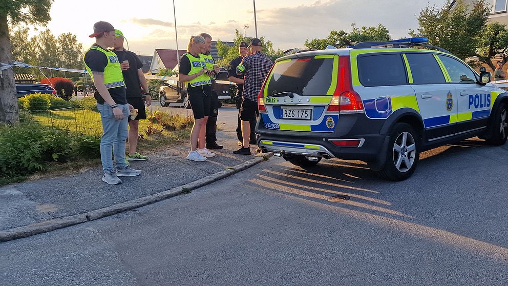 Polisbil, avspärrning och personer i gula västar som håller förhör.