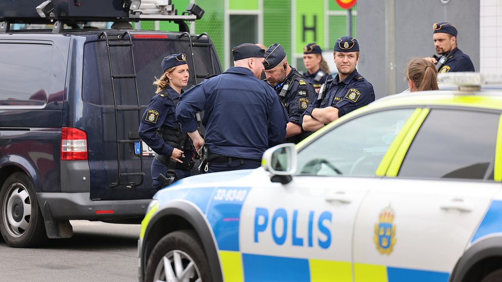 Flera poliser vid en polisbild med armarna i kors.