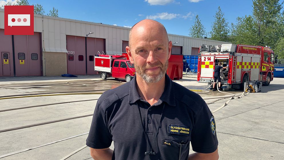 Henrik Jönsson, olycksutredare på räddningstjänsten, en man med kort skägg står framför några brandbilar vid brandstationen i Östersund.