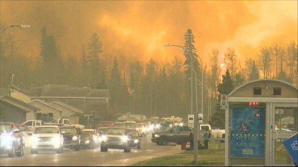 Fort McMurray 2016, himlen är färgad röd av en stor skogsbrand. Vägen är full av bilar då staden evakuerades.