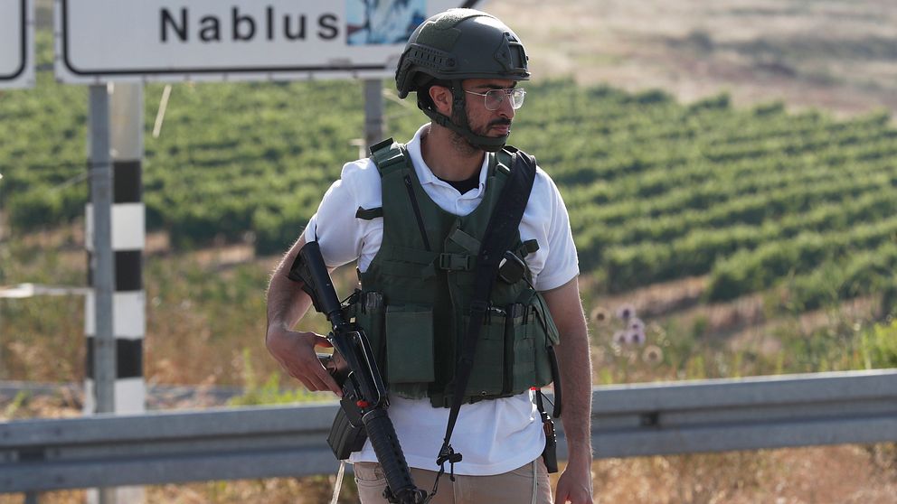 En beväpnad officer i militärkläder från Israels försvarsmakt står vakt vid den israeliska bosättningen på Västbanken.