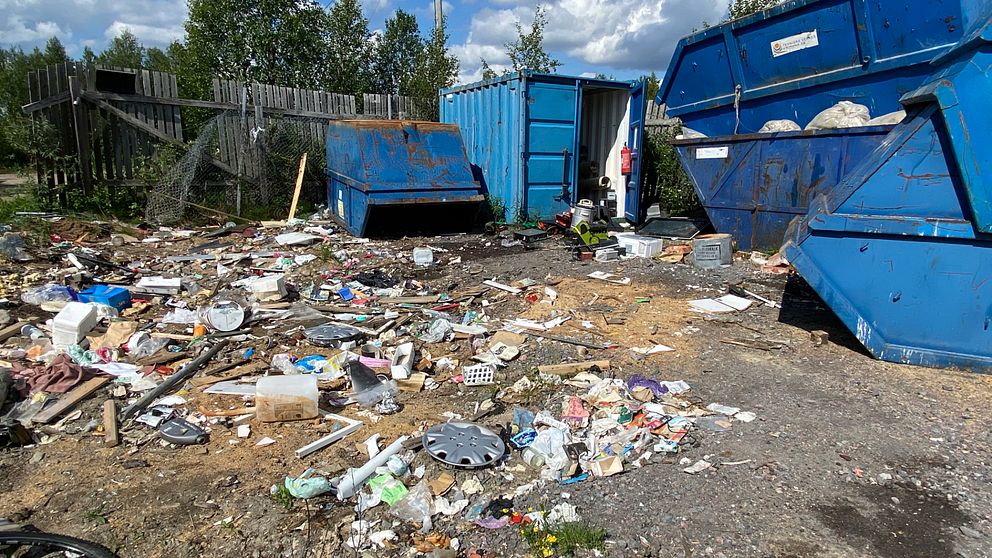 skräpig återvinningscentral, blåa containrar i bakgrunden