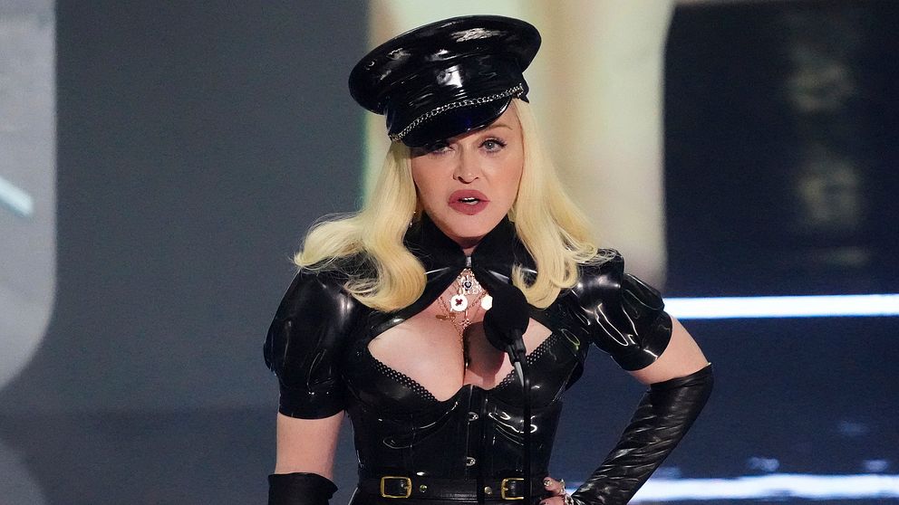 Arkivbild på när Madonna uppträder. Hon är iklädd en läderliknande kostym med tillhörande polisuniforms-liknande hatt.