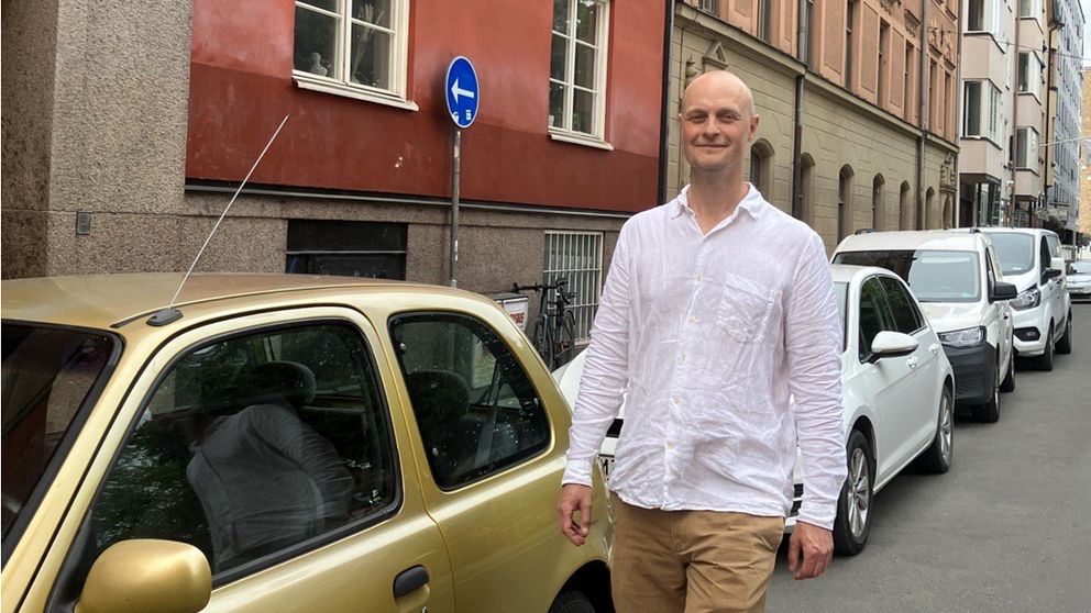 Magnus Björkman, står framför några bilar på en gata.
