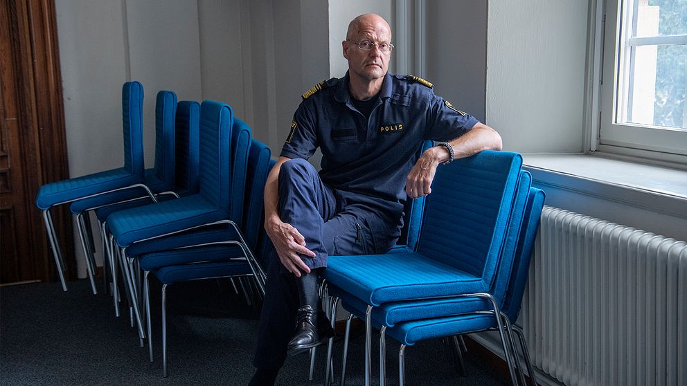 Bild på Mats Löfvings sittandes på en blå stol i en polisuniform.
