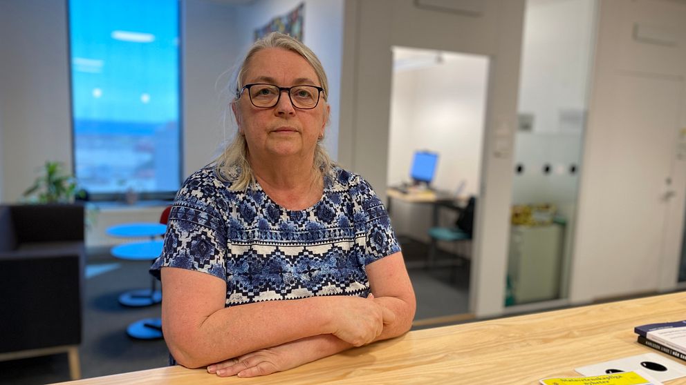 Torun Elsrud, lektor på Linnéuniversitetet sitter vid ett bord i en kontorsmiljö.