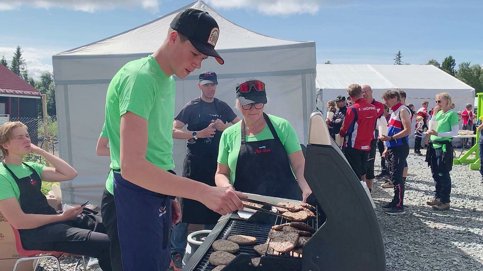 Hugo, en pojke i tonåren iklädd grön t-shirt och svart keps, och grillar hamburgare under O-ringen i Åre.