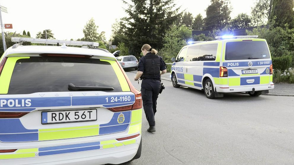 Polisbilar och polis på gatan där skjutningen skedde.