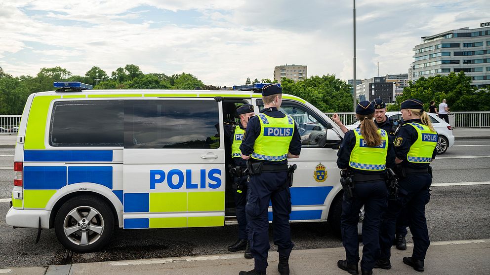 Poliser runt en polisbil