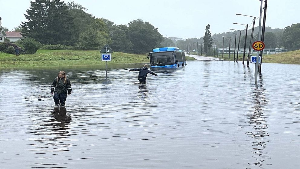 Buss i vattenmassor, barn som leker i vattnet