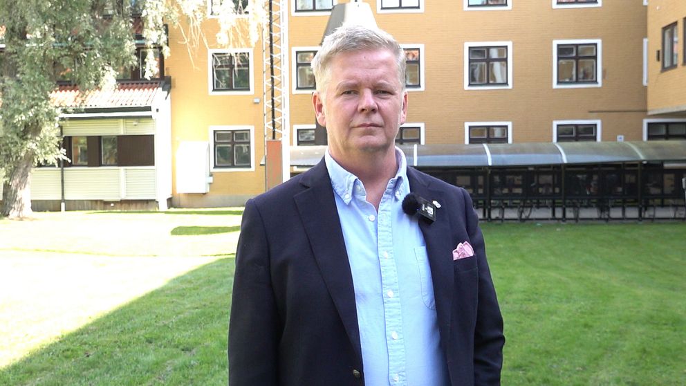 Lars Lustig står framför länsstyrelsen i Västerbotten, ett gult tegelhus.