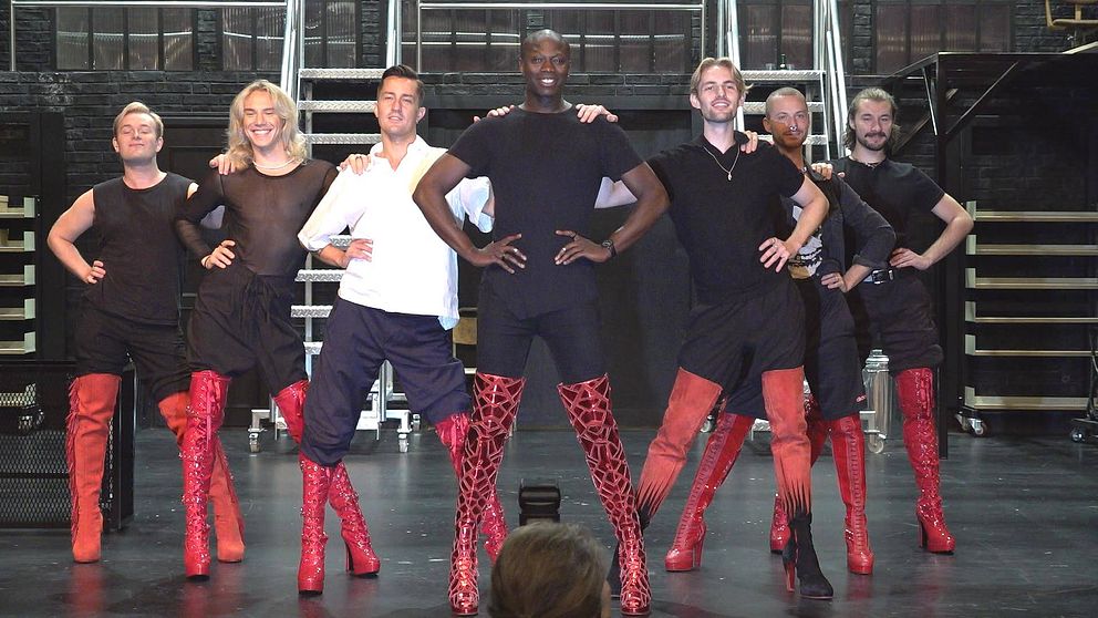 Skådespelare och dansare i musikalen ”Kinky Boots” poserar på scenen.