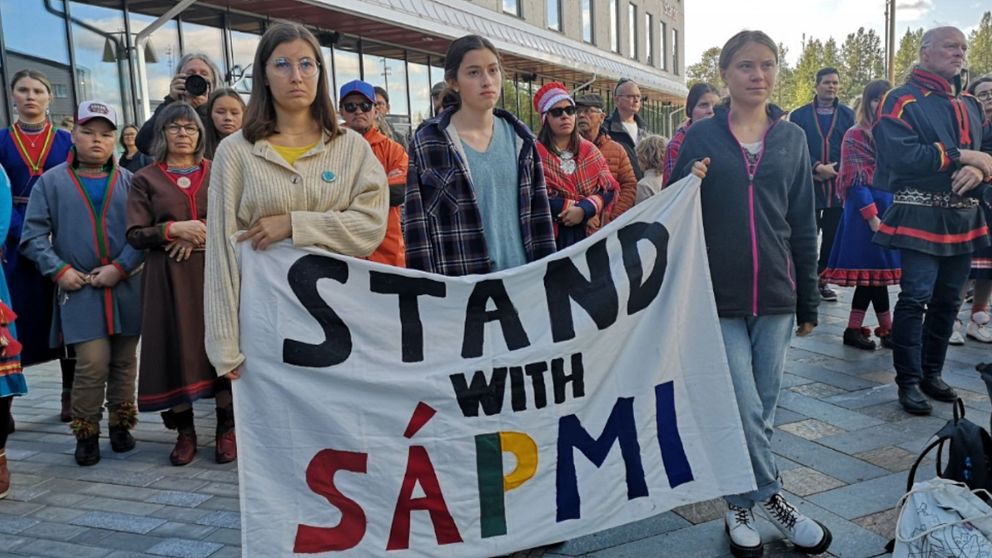 Greta Thunerg med två andra demonstranter med en banderoll