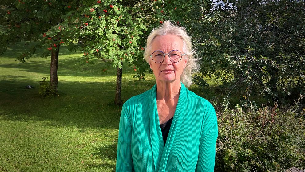 Åse Schoultz, åklagare står med grön tröja och runda glasögon.