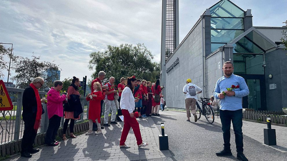 Personer från Göteborgs stift i klädda i rött utanför Göteborgs moské.