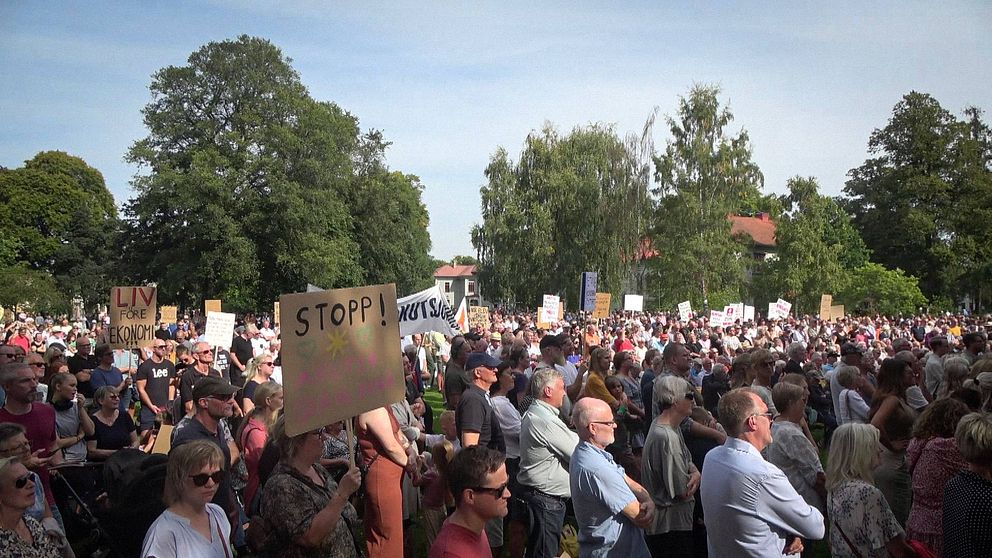 En folkmassa med plakat där de protesterar mot nedläggning av Lidköpings akutmottagning