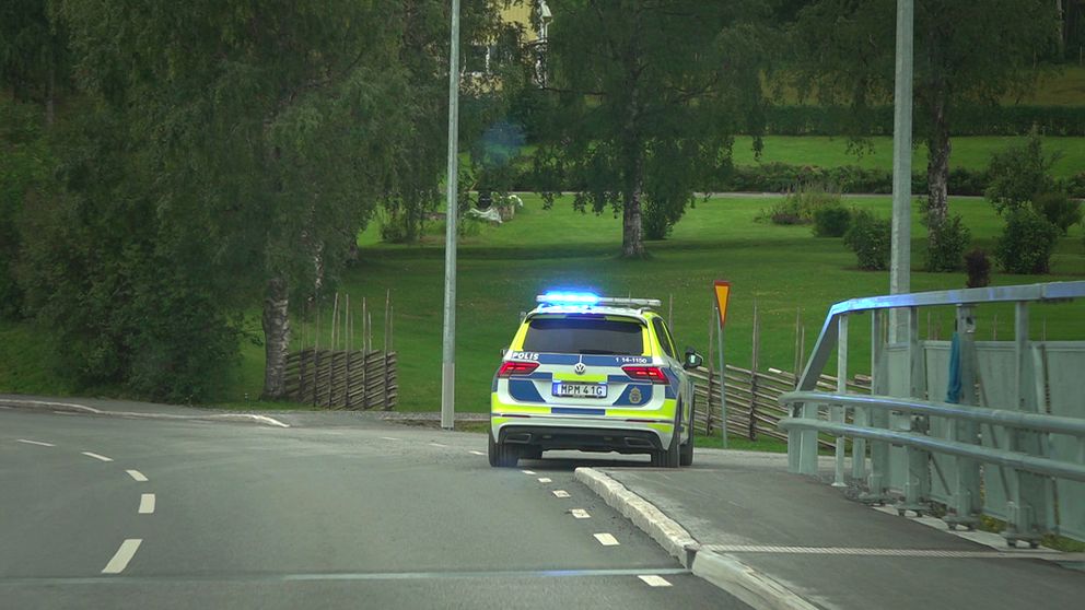 Polisbil som står parkerad med blåljus på bredvid en bro i Lit.