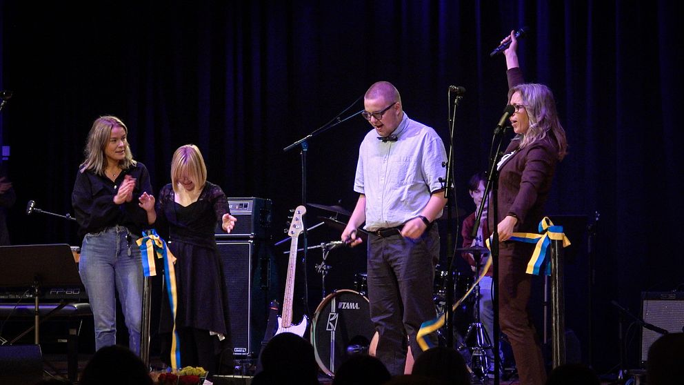 Malin Rhode klipper ett band tillsammans med eleven Carl Gustafsson på scen.