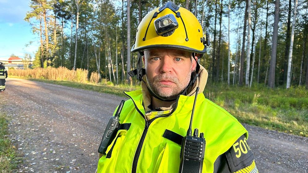 Brandman med gula varselkläder och gul hjälm.