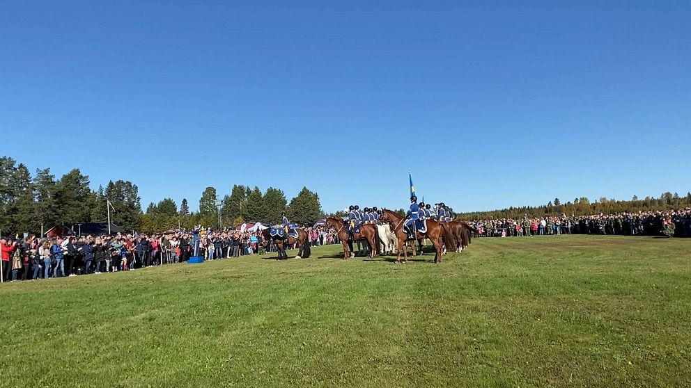 slätt med personer till häst och publik runt omkring