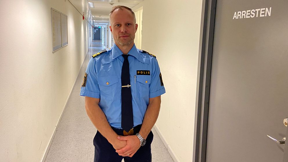 Emil Andersson, chef utredningsjour hos Polisen i Malmö står i en korridor. Bredvid en dörr där det står ”ARRESTEN”.