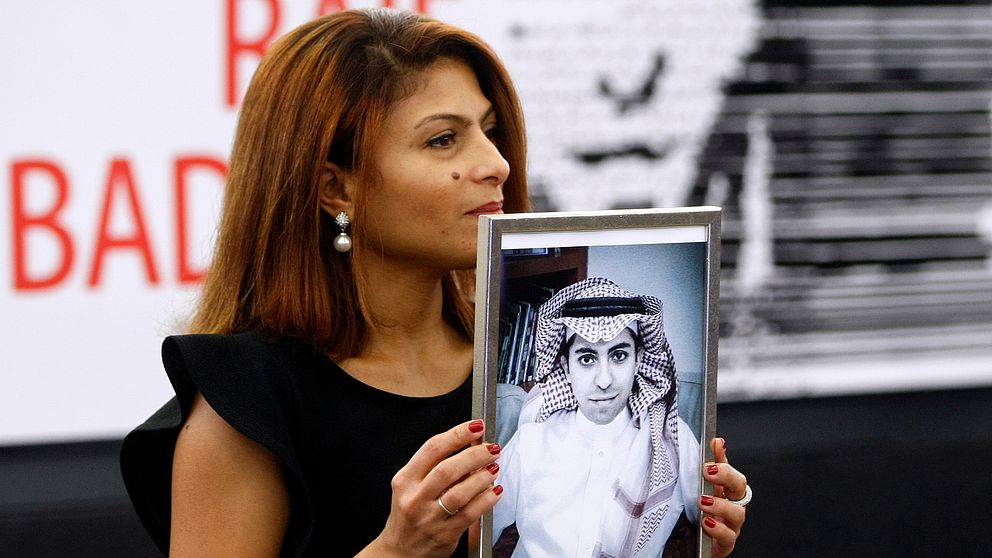 Ensaf Haidar visar upp ett porträtt av sin fängslade make, bloggaren Raif Badawi.