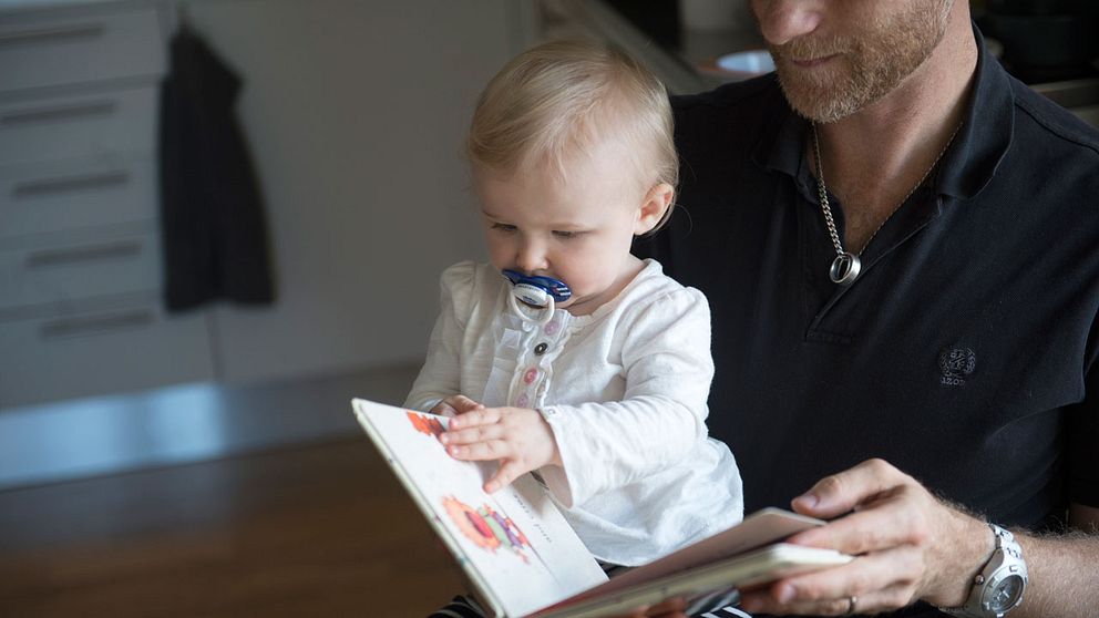 Pappa läser för sitt barn.