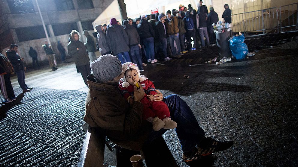 En syrisk man med sin dotter utanför ett registreringscenter för asylsökande i Berlin.