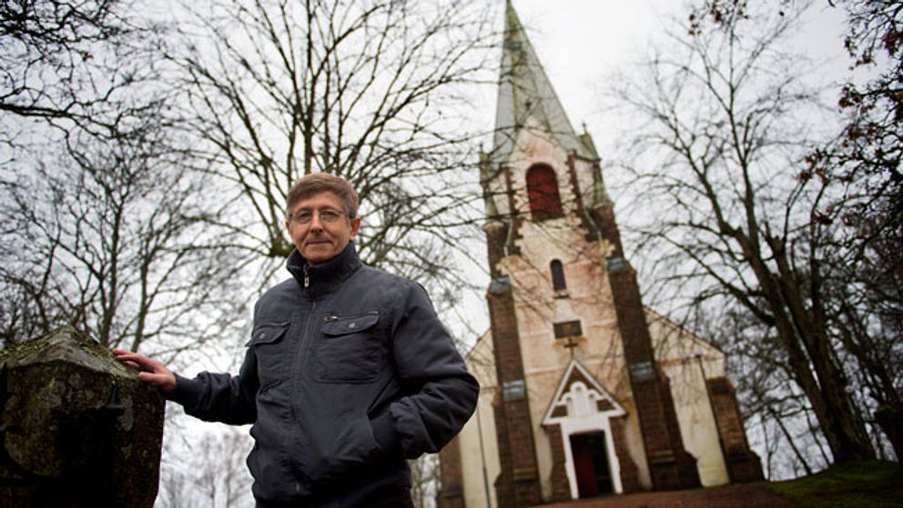 Kyrkoherde Willy Hjalmarsson framför Kalvs kyrka utanför Svenljunga som man tvingas stänga under vissa tider på grund av sviktande besökarantal.
