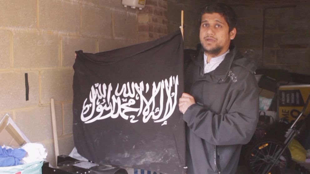 Abu Rumaysah visar upp IS-flaggor som han förvarar i sitt garage i östra London.